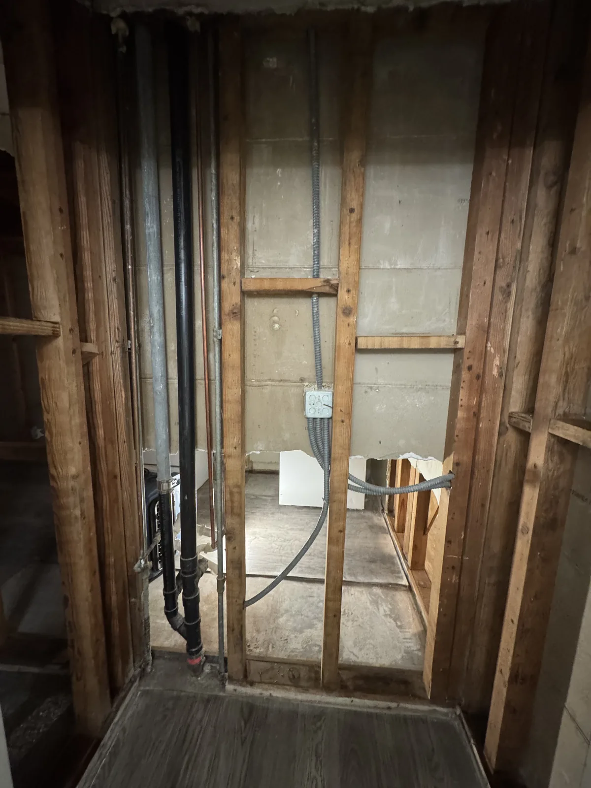 A bathroom stripped back to the studs with the new pipework in place