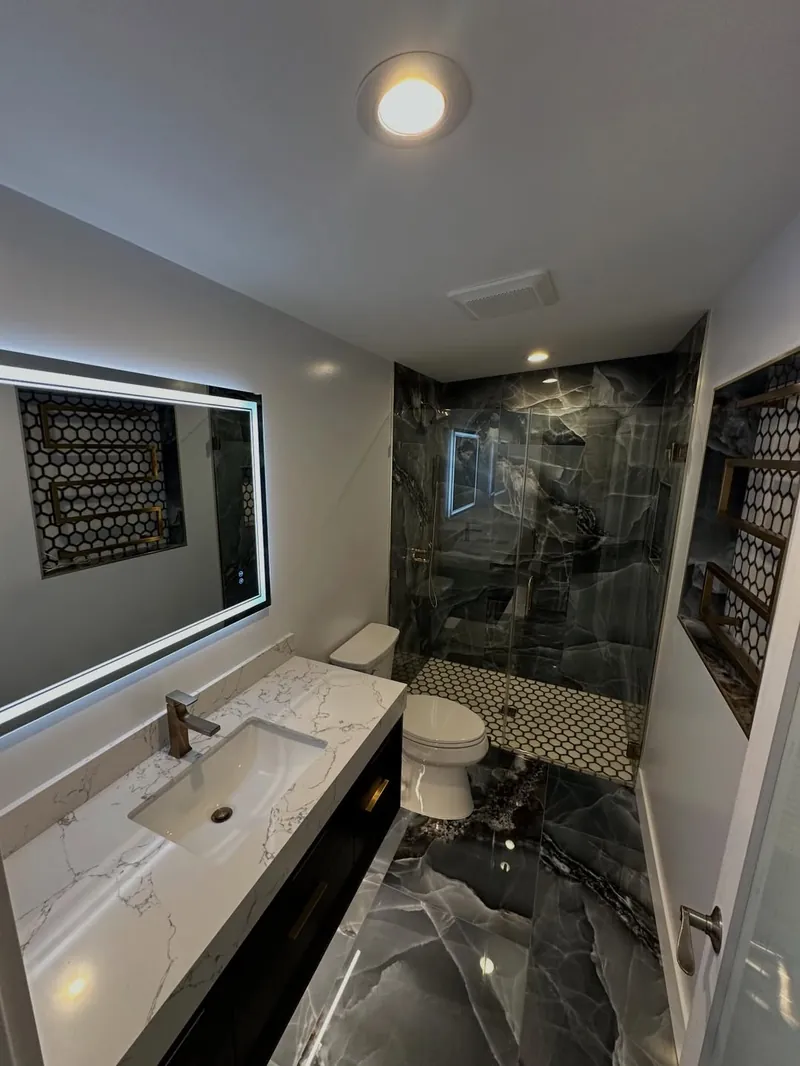 A finished bathroom with a tiled tub surround and a double vanity