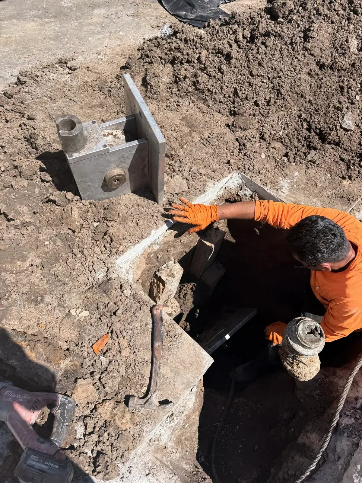 A compact pit opened at the sewer lateral with the cleanout fitting set in it