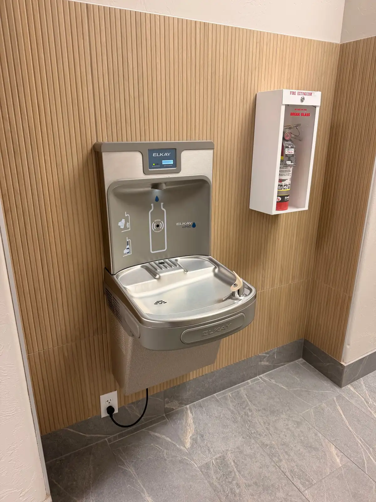 A bottle filling station and accessible drinking fountain installed and plumbed in a commercial building
