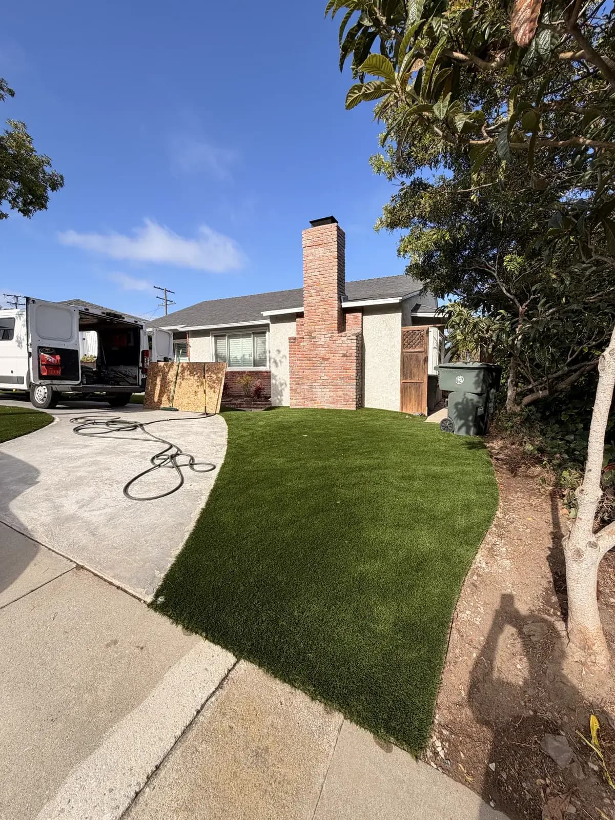 A house and its front yard from the street, the drive and lawn undisturbed after the work