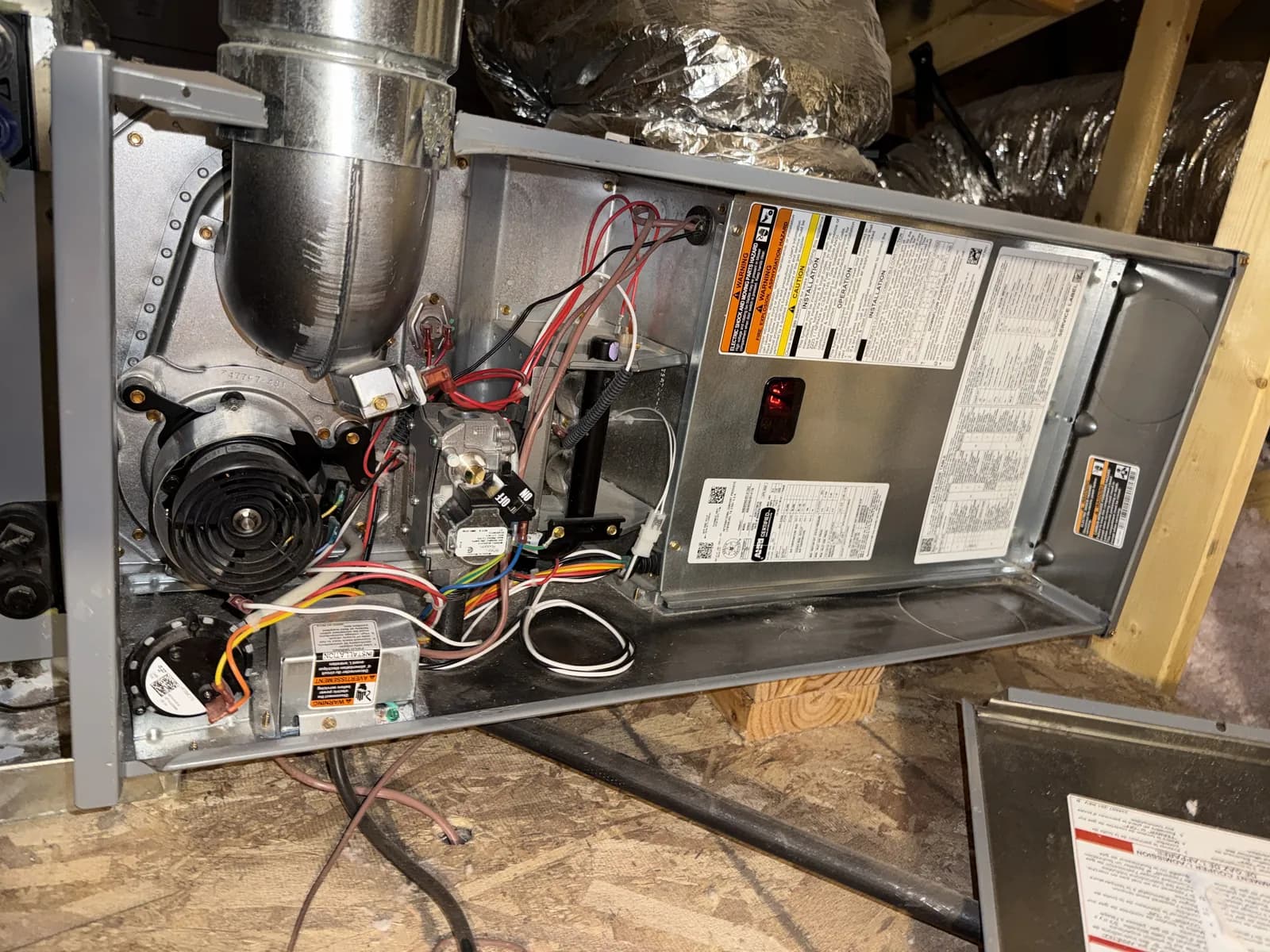 The same furnace after service, the cabinet and burner compartment clean and the wiring dressed back against the panel