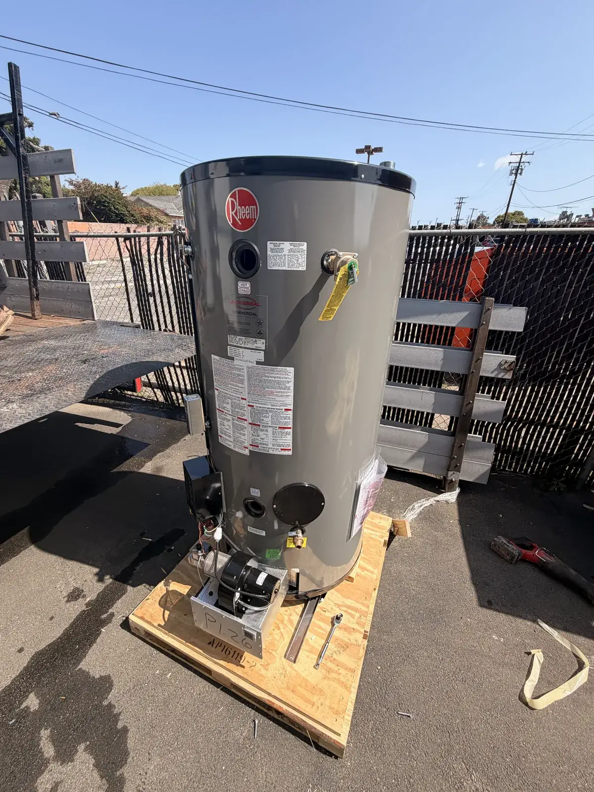 A new water heater strapped to a pallet, delivered to the job before the old one is disconnected