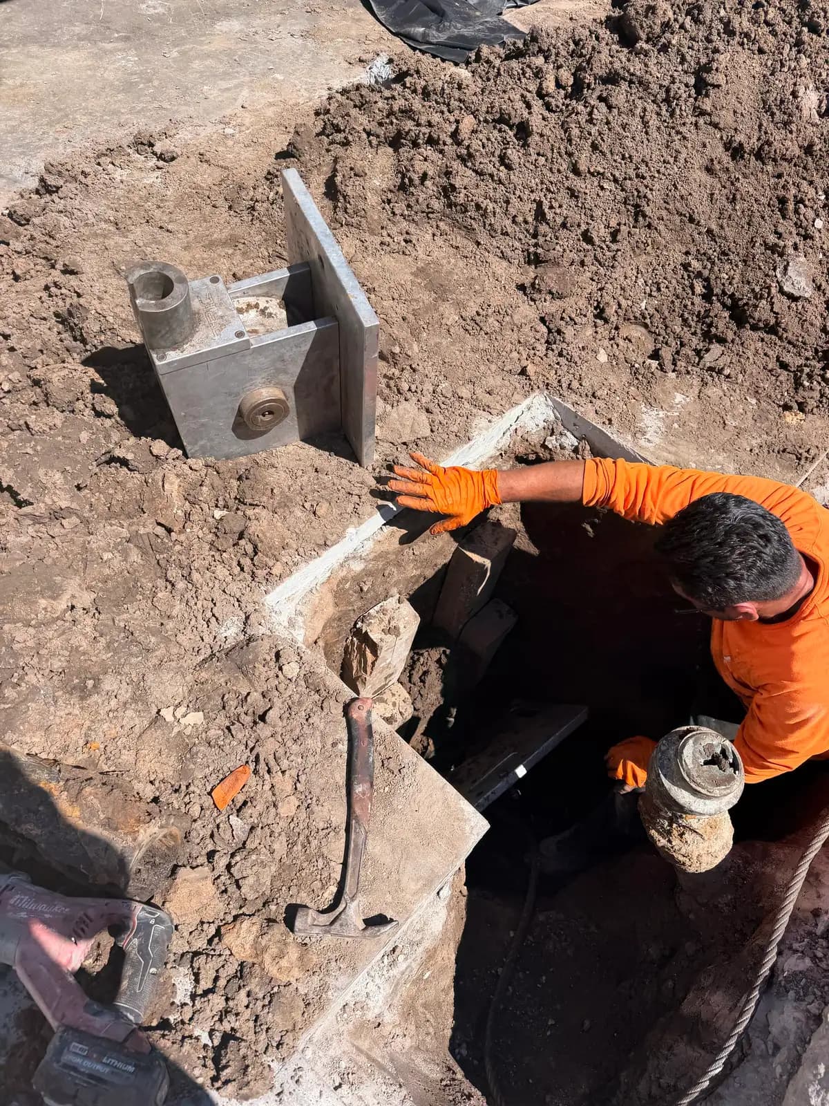 A technician working in a compact launch pit at the sewer cleanout