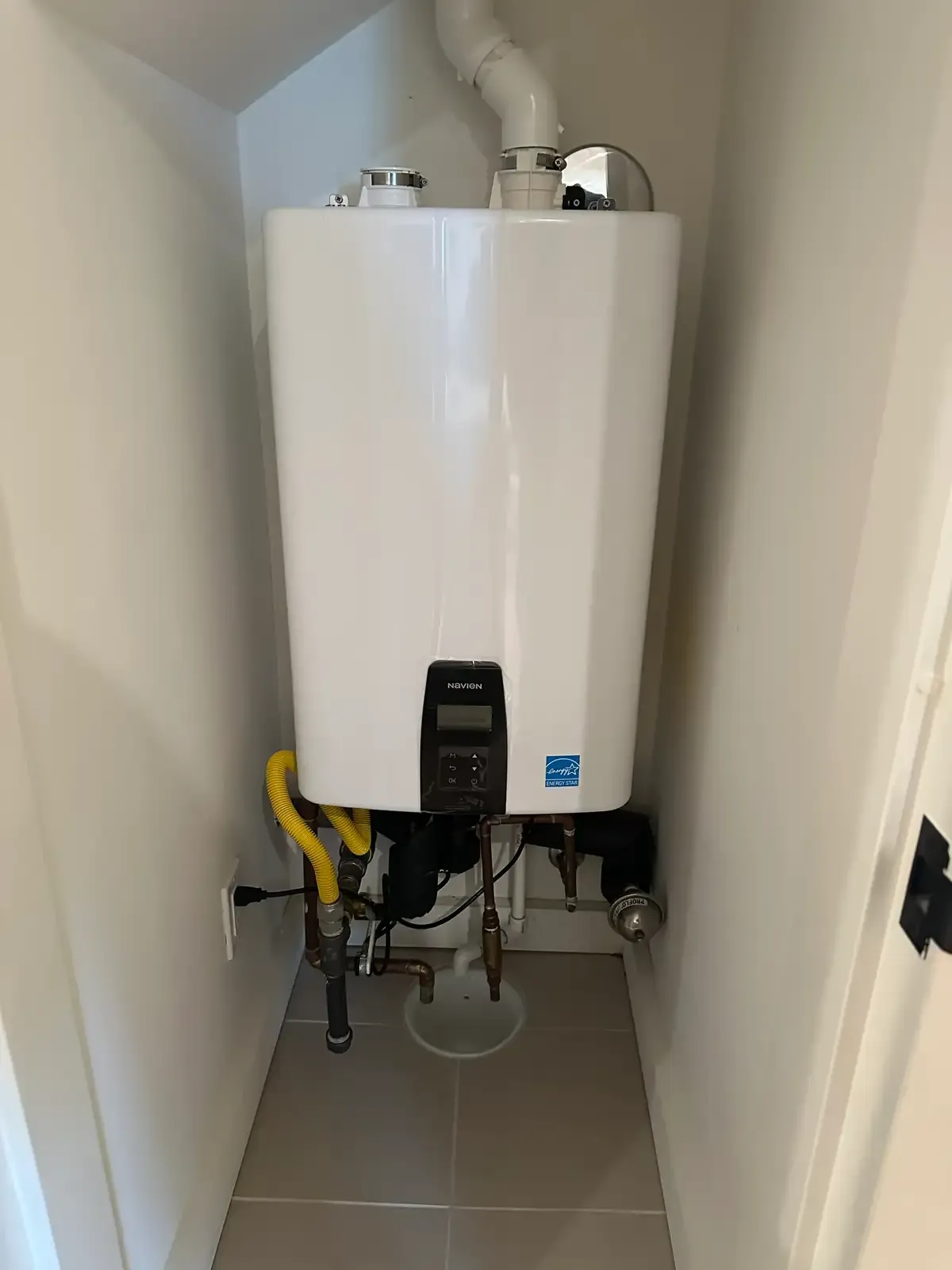 A wall-mounted condensing tankless water heater with its gas, water and venting connections made up