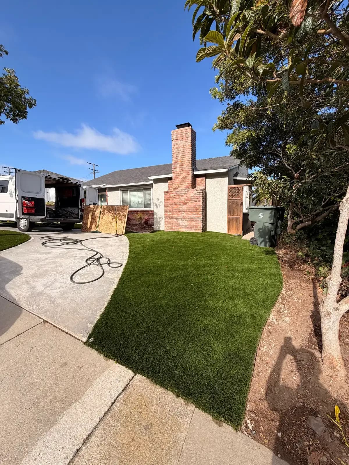 A front yard with intact turf and driveway after a sewer replacement, with no sign of digging